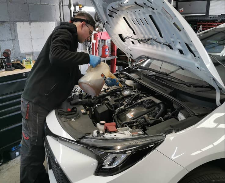 Dan working professionally on a car engine